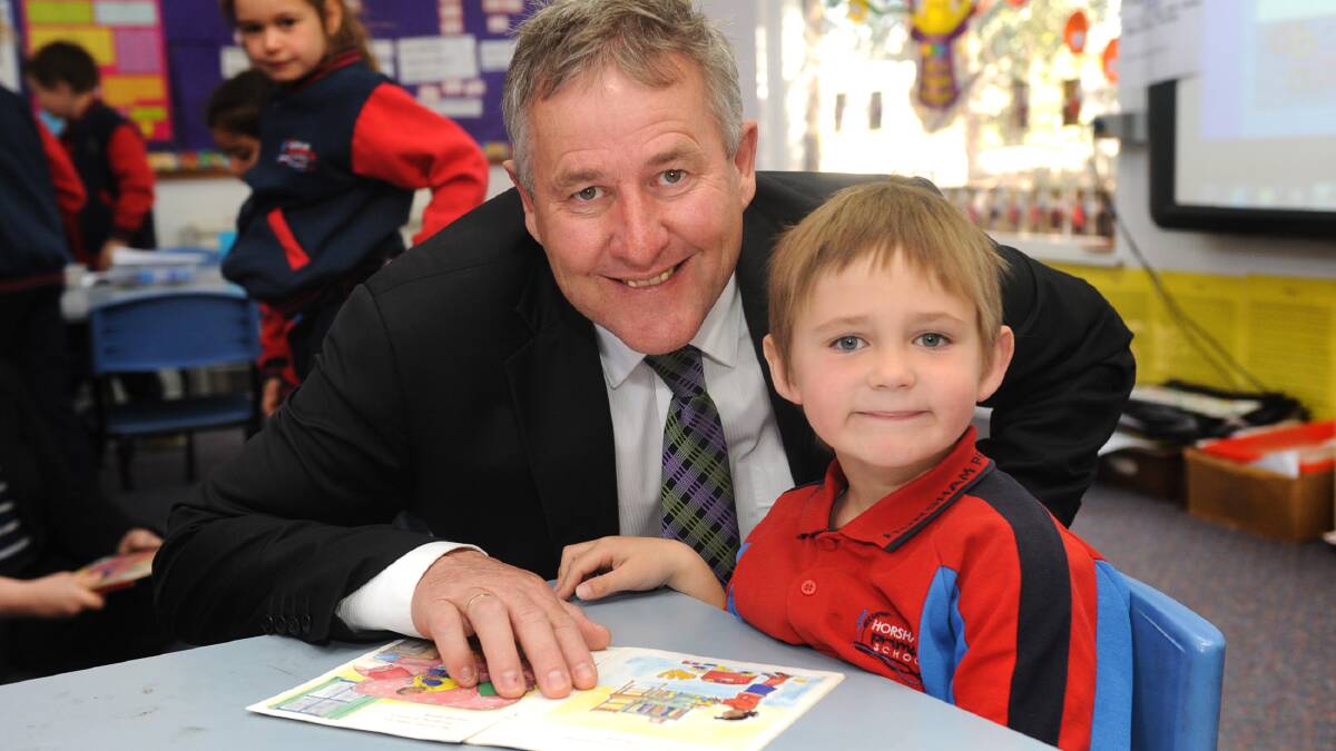 LEARNING TOGETHER: Horsham Rural City Mayor David Grimble reads to Blair Clark during his stint as principal at Horsham Primary School this week. Picture: MELINDA SCHMIDT