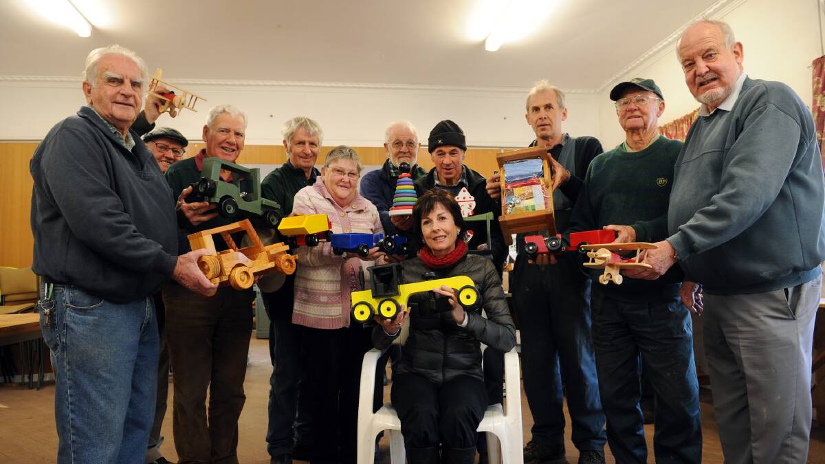 WORTHY DONATION: Red Cross national community programs head Kerry McGrath collects toys for migrant families from Wimmera Woodturners Guild members. Picture: PAUL CARRACHER