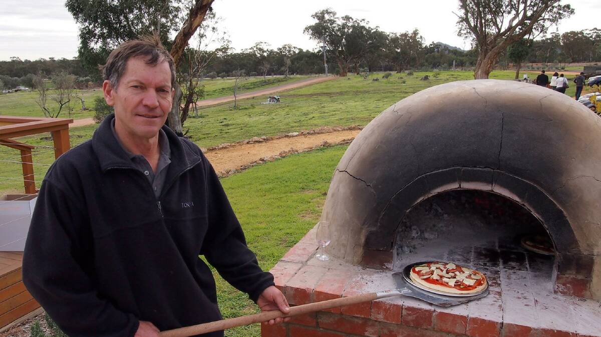HOT OFF THE PRESS: Toscana Olives’ Andrew Mathews cooks a woodfire pizza at the grove’s open day on Sunday. Picture: CONTRIBUTED