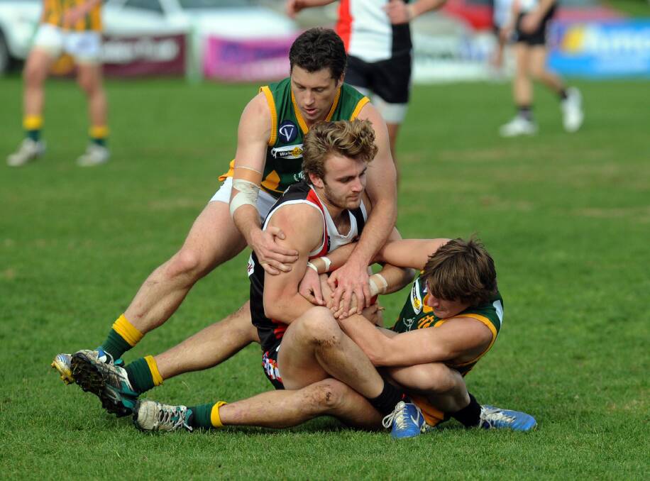Dimboola's Ash Clugston and Simon Clugston wrestle with Horsham Saint Les Butler for the ball during a clash between the sides last year. The two teams will meet again on Saturday. Picture: PAUL CARRACHER