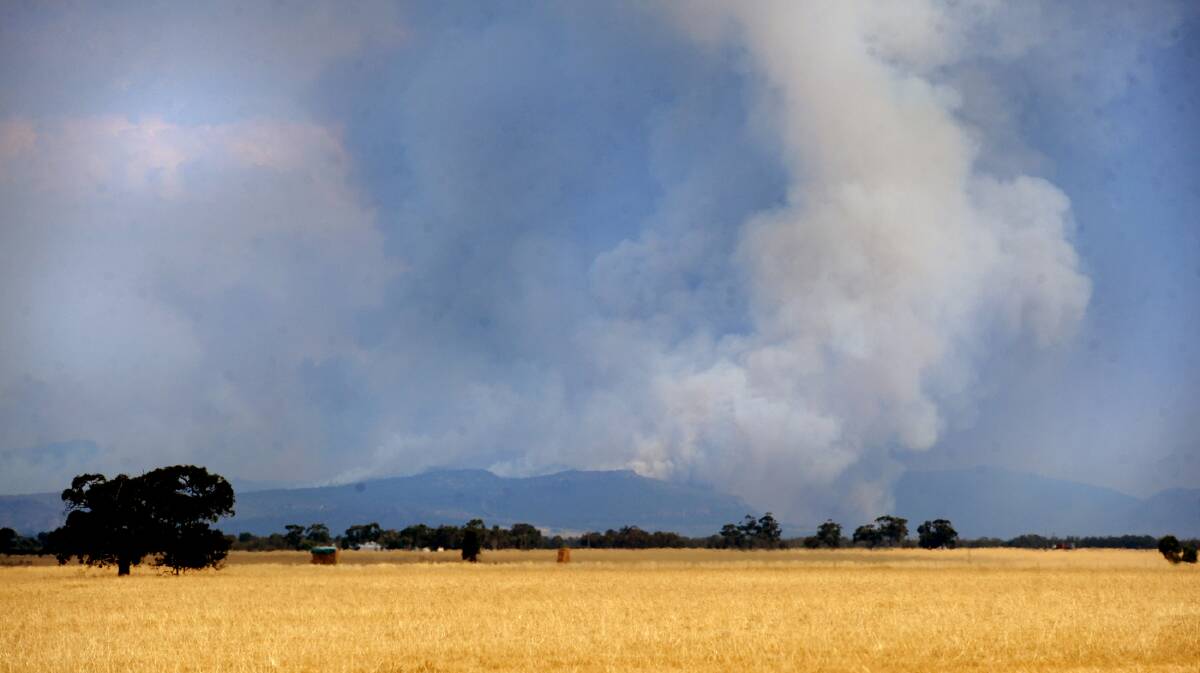 DANGEROUS: Smoke wafts above the Grampians as fires burn on January 16. Though the fire is now behind containment lines, it is still active and could flare again. Picture: SAMANTHA CAMARRI