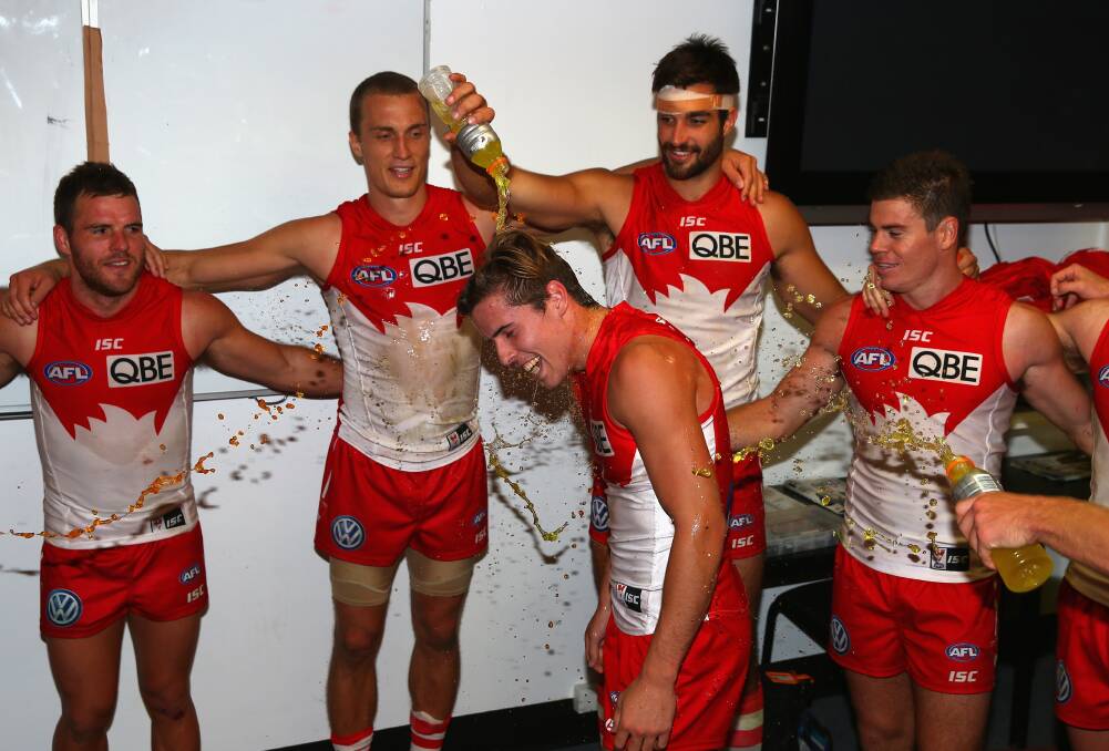 SHOWER: Jake Lloyd celebrates the Swans win with team-mates. Picture: GETTY IMAGES