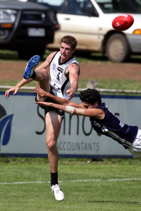 JUST IN TIME: North Ballarat Rebels player James Richards gets a kick away under pressure from Geelong Falcon Aaron Christensen.  Picture: DAMIAN WHITE, WARRNAMBOOL STANDARD