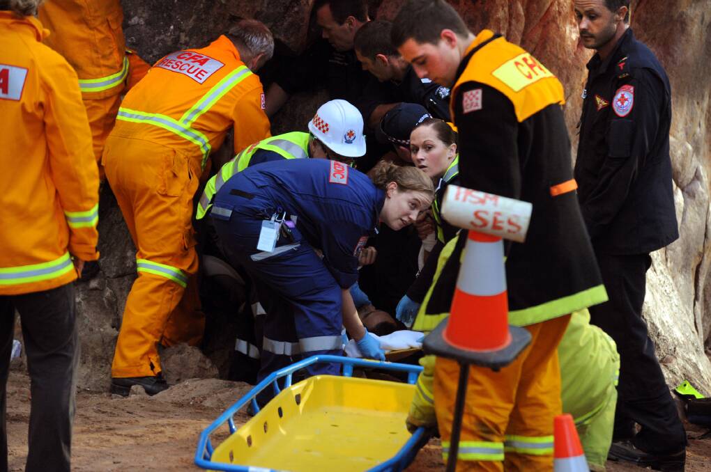 MOMENT OF RESCUE: Country Fire Authority, Victoria Police, Ambulance Victoria and State Emergency Service crews, along with Arapiles Rescue Group members, free a man from a rock crevice at the base of Mt Arapiles on Tuesday morning. Picture: PAUL CARRACHER