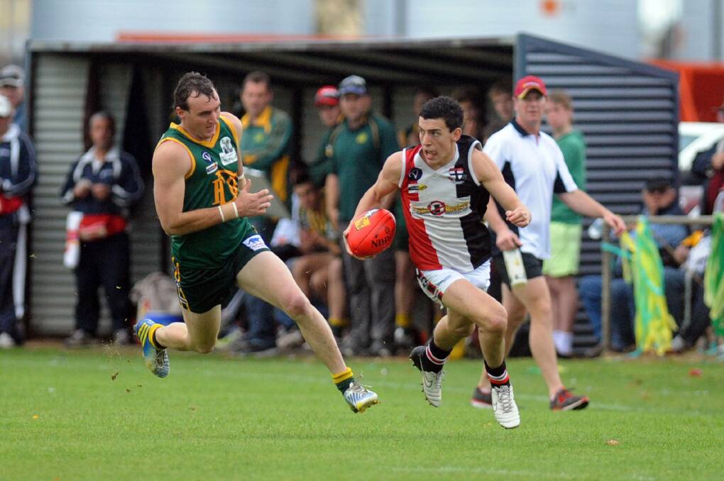 ACTION: Horsham Saint Conor O'Beirne tries to evade Dimboola's Nigel Sibson during the 2013 WFL grand final. Pictures: PAUL CARRACHER