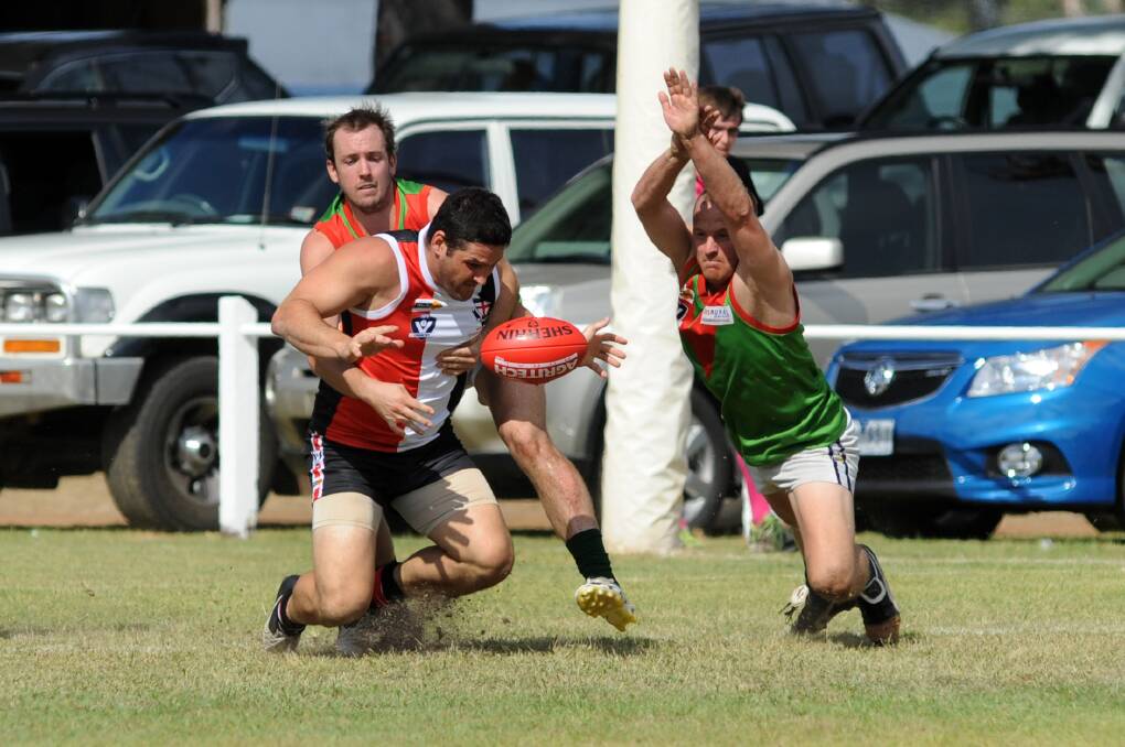 Noradjuha-Quantong's Brady King tackles Brendan Fevola while Lachie Wilson tries to smother.