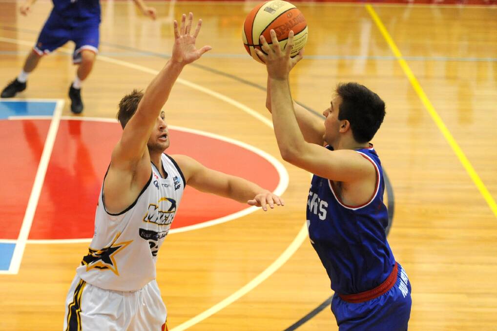 LETTING FLY: Nunawading Spectre Costas Hronopoulos launches a three-pointer with Ballarat defender and Horsham product Ash Constable in his face.