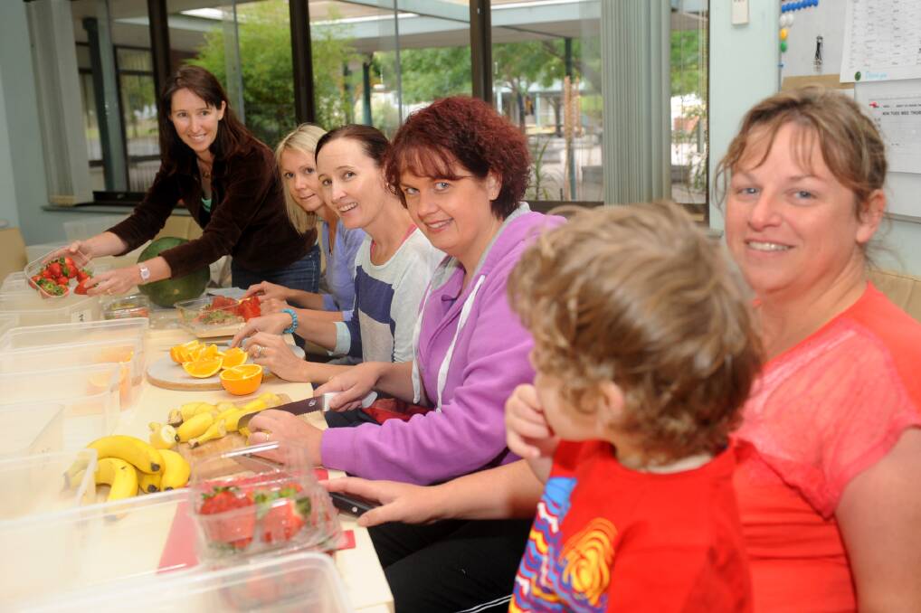 HEALTHY EATING: Previous co-ordinator Michelle Kinsman, Kelly Miller, Sophie Slatter, Tamara Hallam-Brook and Carmel Quick, with her son Lachlan, 3, prepare food for the Fresh Fruit Friday initiative at Horsham West Primary School. Picture: SAMANTHA CAMARRI