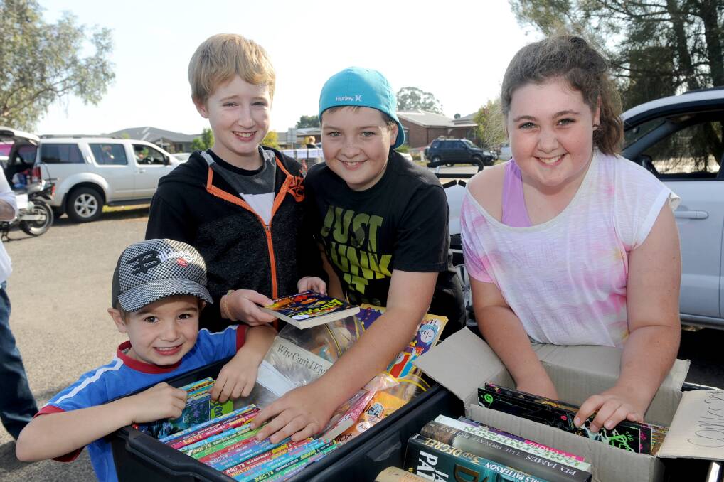 FOR SALE: Horsham’s Will Robertson, 5, Jayden Robertson, 12, Jack Sleep, 12, and Kate Sleep, 10, search for a bargain at Horsham West Primary School’s car boot sale on Sunday. Pictures: SAMANTHA CAMARRI