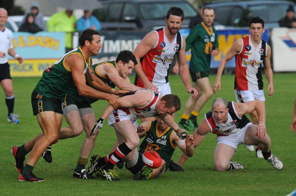 GROUP TACKLE: Horsham Saint Steve Thomas is tackled by Dimboola's Peter McFarlane and Clancy Bennett during the 2013 WFL grand final.
