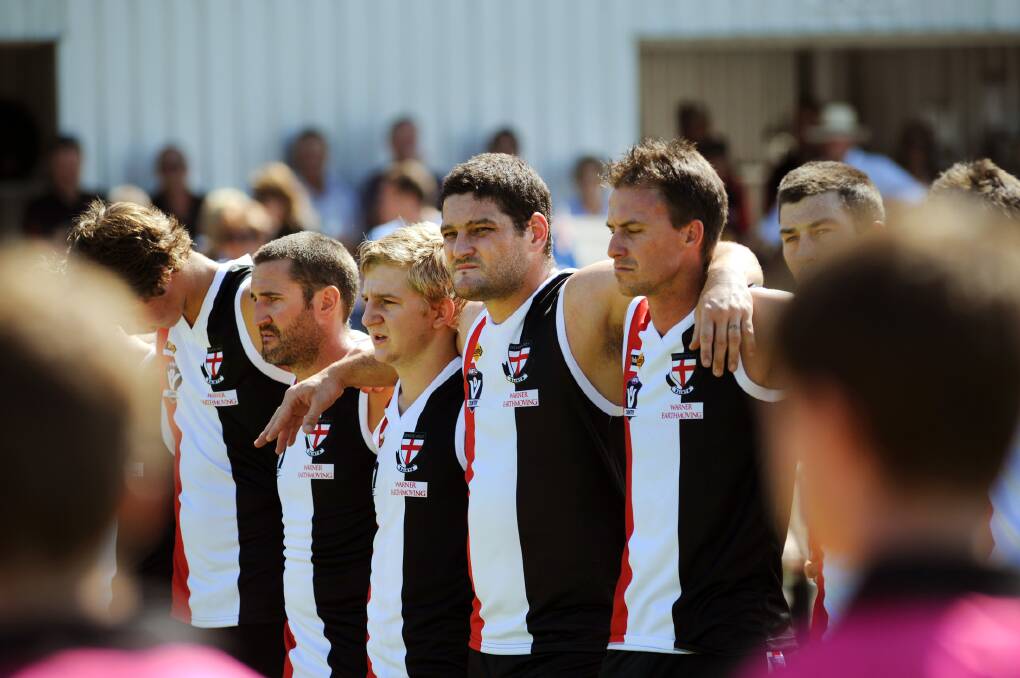 RESPECT: Former AFL star Brendan Fevola, centre, was a guest player for Edenhope-Apsley at the weekend in its opening Horsham District Football Netball League game for the year. All players observed a minute’s silence before the game to remember Edenhope-Apsley Football Netball Club secretary and past president Neville Forster, who died last month.  SCROLL THROUGH for more photos. Pictures: PAUL CARRACHER