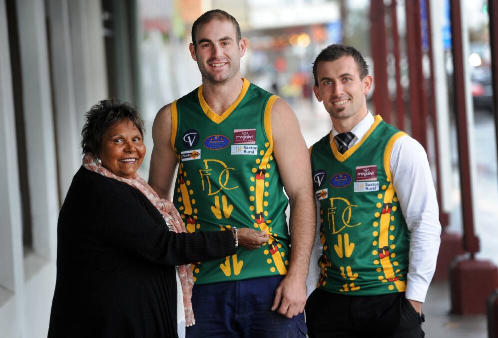 INDIGENOUS COLOURS: Suzie Skurrie and Dimboola footballers Justin Chilver and Andrew Seers show off the indigenous jumpers the Roos will don on Saturday. Picture: PAUL CARRACHER