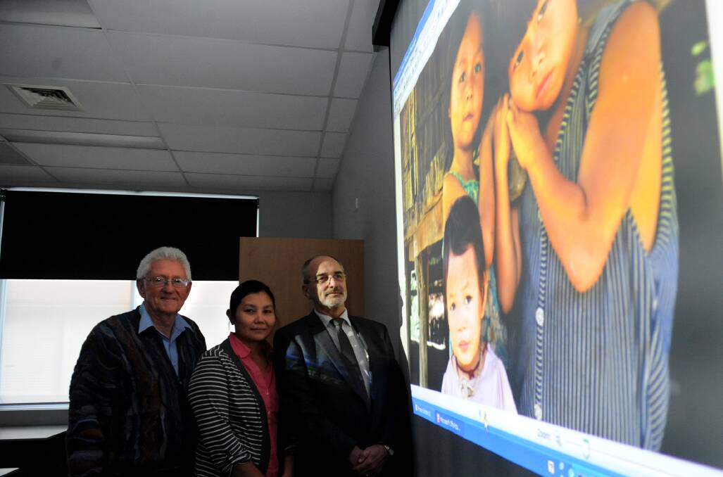 REFLECTIONS: Wimmera Settlement Committee gathered for a Life Through the Lens photographic exhibition as part of National Refugee Week on Monday night. Community representative John Millington, left, refugee Hserwah Po Kauyt and chairman John Ackland take a closer look at one of the photos. Picture: SAMANTHA CAMARRI