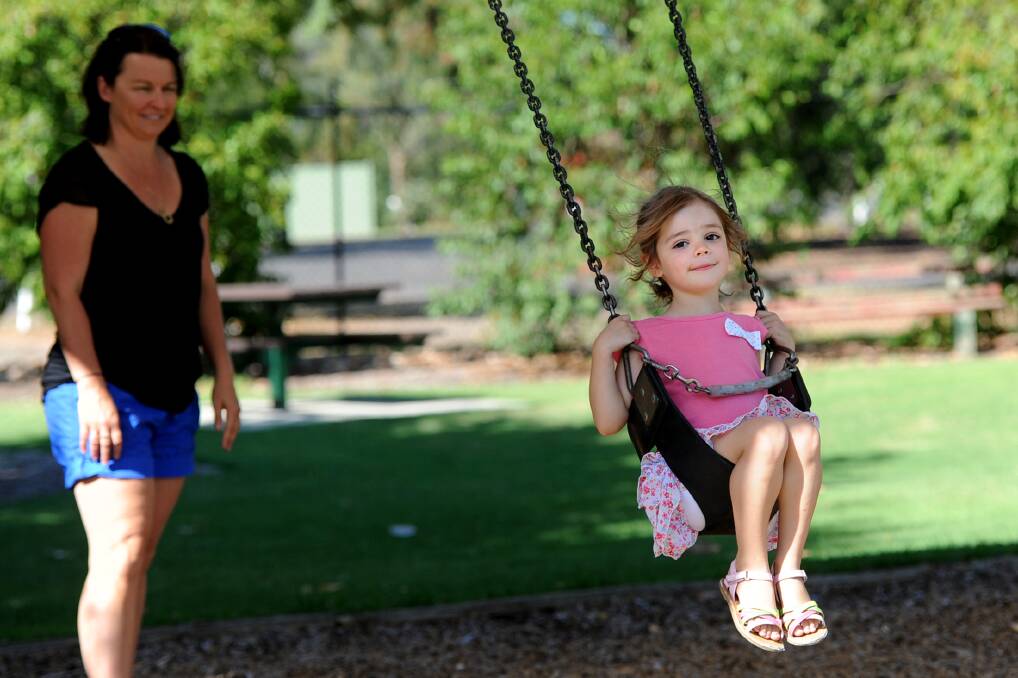 SMOKE FREE: Lucy Pietsch, 4, enjoys a swing at Horsham Botanic Gardens on Tuesday, as Tracey Pitts looks on. Picture: SAMANTHA CAMARRI