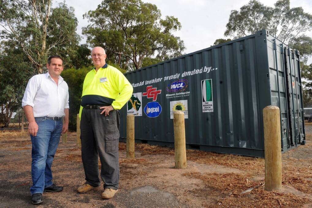 GENEROSITY: Wimmera Container Line’s Allister Boyce with BlazeAid co-ordinator Barry Thompson and the shipping container the business has donated for BlazeAid volunteers to store their tools. Picture: SAMANTHA CAMARRI
