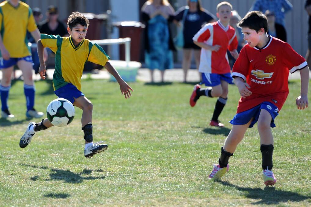 Horsham and District Soccer Club members Jaara Secombe runs with the ball while Sam Lyons looks to defend during an internal soccer grand final last year. The club will focus on socialisation to improve its players. Picture: SAMANTHA CAMARRI