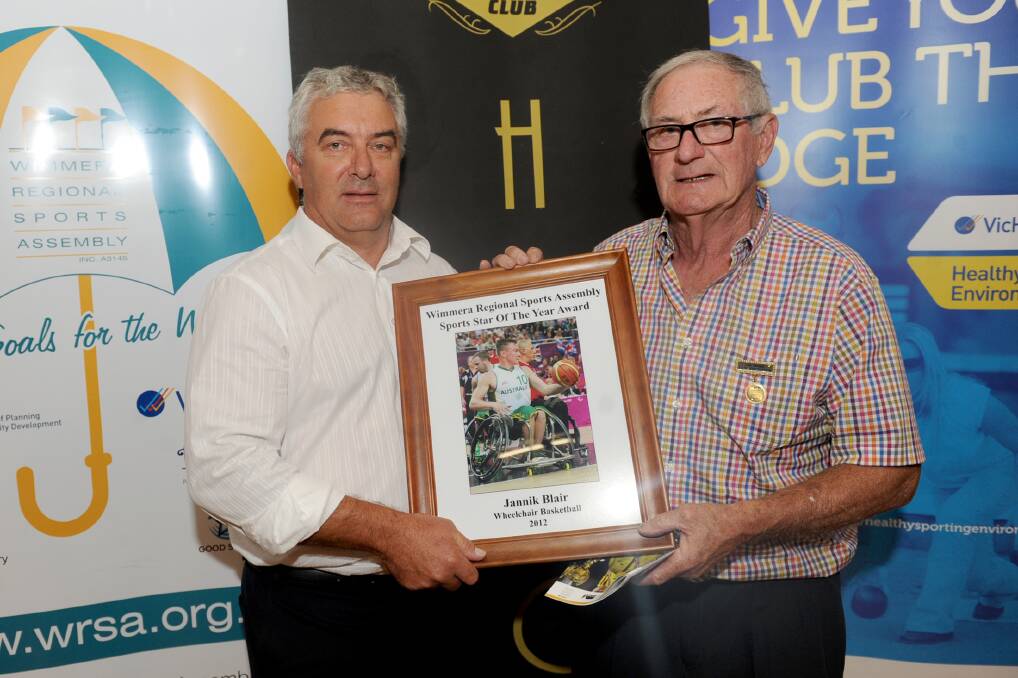 INDUCTED: Wheelchair basketball star Jannik Blair was inducted into the hall of fame at the Wimmera Sports Star of the Year award on Monday night. Blair's father Peter Blair accepts the award on his behalf from Ian Fechner. Pictures: SAMANTHA CAMARRI