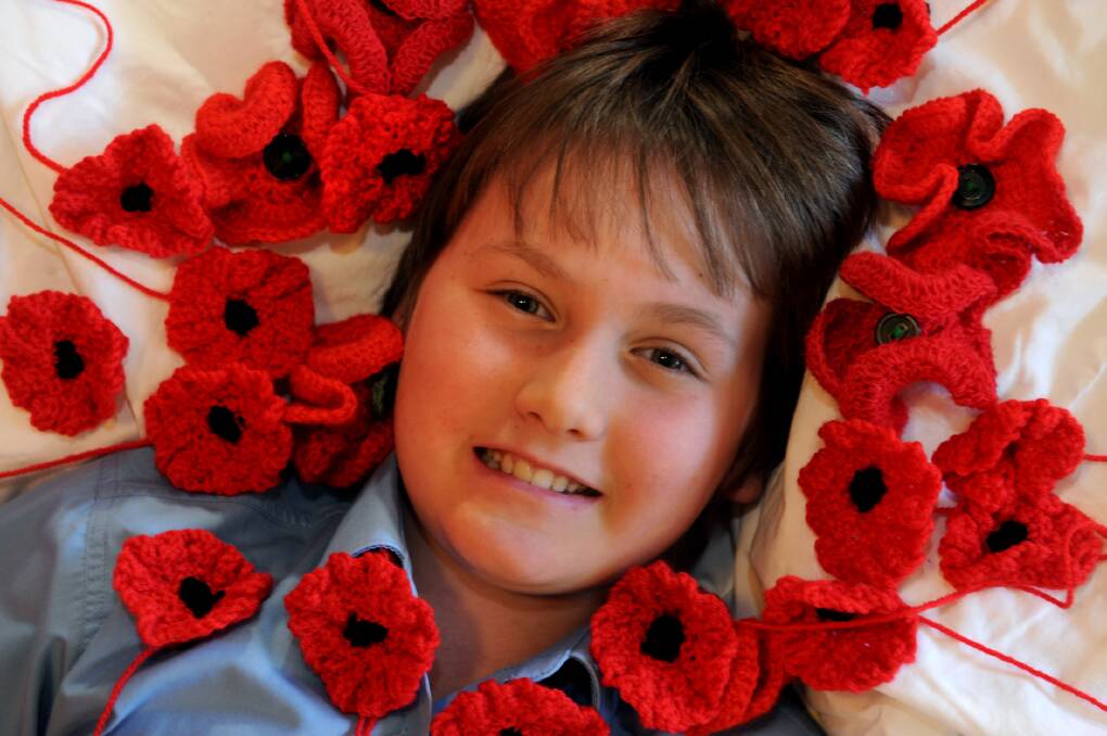 POPPY DRIVE: Leroy Ashburn, 10, with poppies knitted for Anzac Day. Picture: PAUL CARRACHER