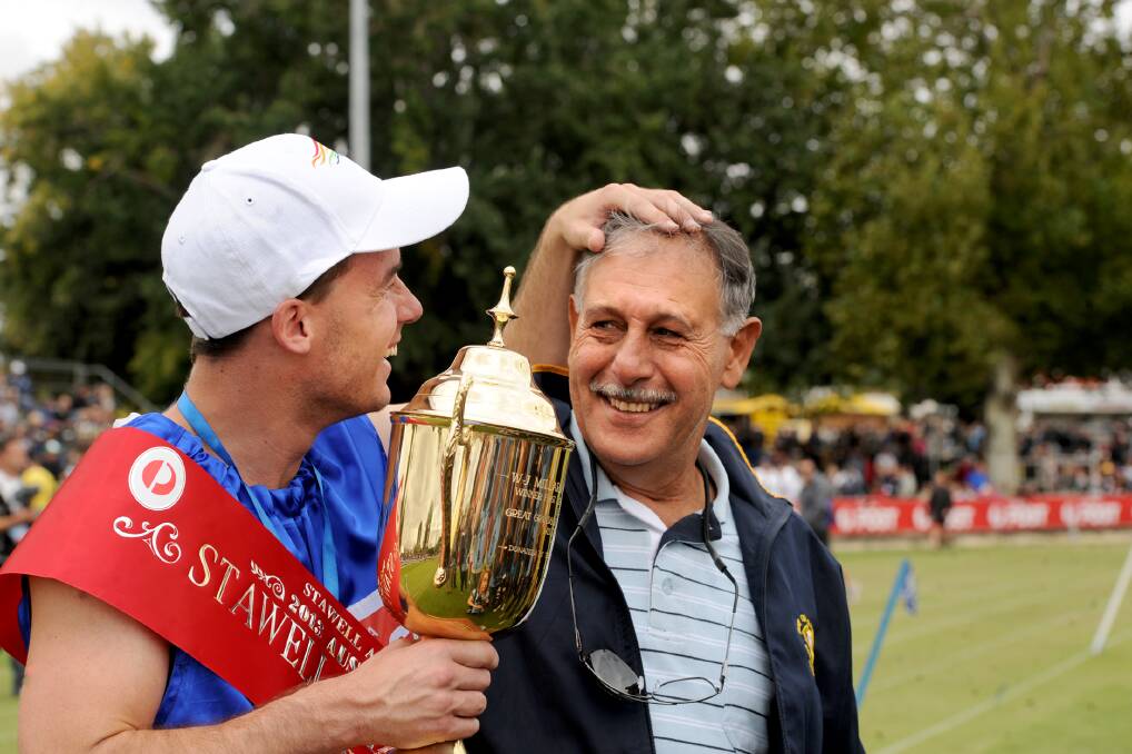 GRIN: Andrew Robinson, with coach Ray Quarrell, after winning the 2013 Stawell Gift. Picture: SAMANTHA CAMARRI