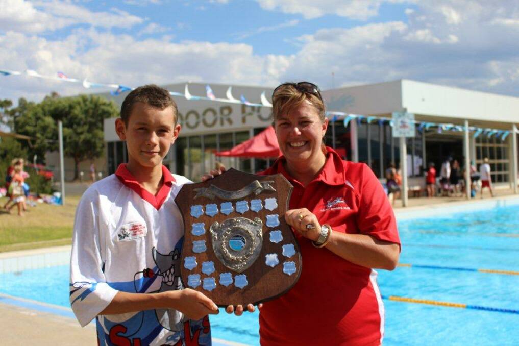 SHARK ATTACK: Horsham Swimming Club captain Luke Bone receives the McKenzie Shield from Ararat Swimming Club President Ainsley Cameron at the Stawell Leisure Centre on Saturday.