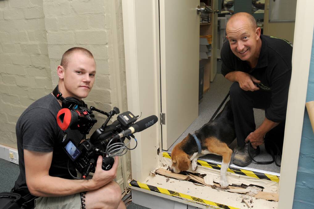 LIGHTS, CAMERA, ACTION: Bug R Off Pet Busters owner Steve Olver, right, and termite detection dog Buster show The Project cameraman Stu Heppell how they go about their business. Picture: SAMANTHA CAMARRI