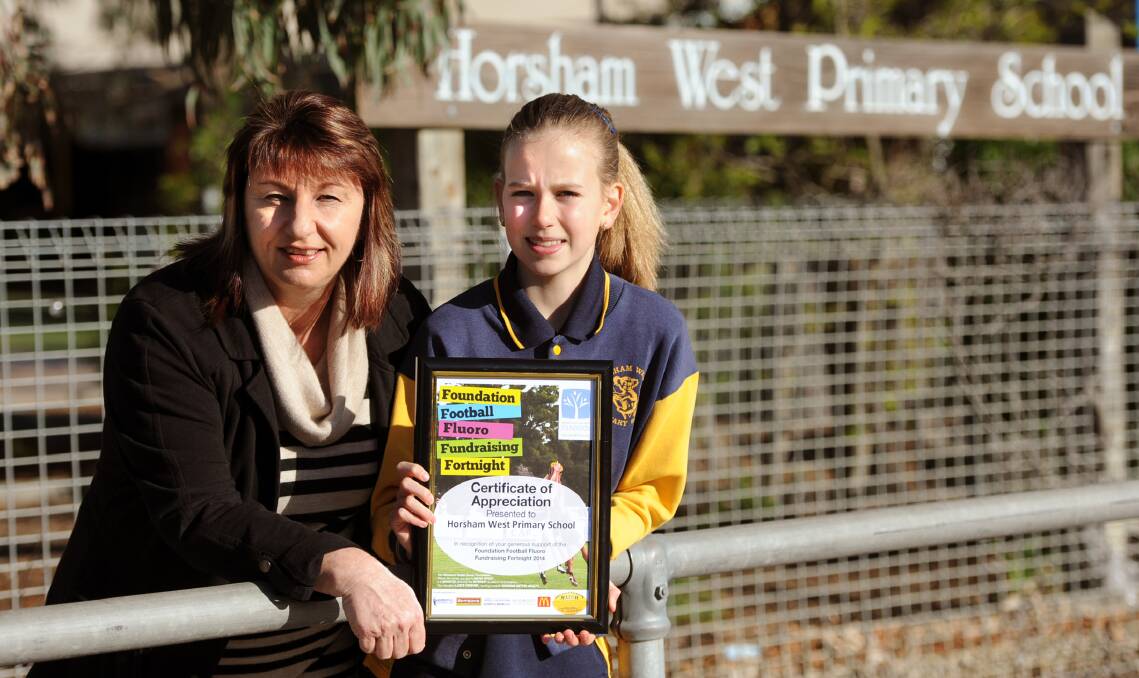 GENEROSITY IN THE SPOTLIGHT: Foundation Fluoro Football Fundraising Fortnight organiser Debbie Simpson presents Horsham West Primary School junior school council representative Katianna Grosser with a certificate of appreciation for the school’s support for the cause. Picture: SAMANTHA CAMARRI