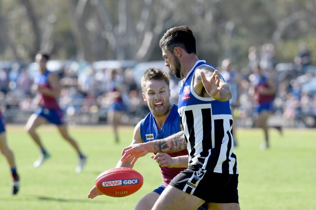 Minyip-Murtoa coach Damian Cameron gets a kick away before Horsham's Deek Roberts comes in from the side. Picture: SAMANTHA CAMARRI