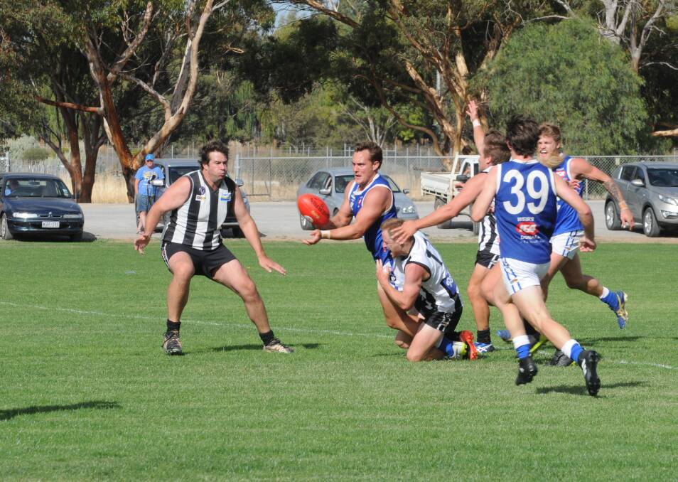 UNDER PRESSURE: Donald's Tom Bell gets a handball away despite the pressure being aplied by Boort's Ben Gregg in round one. Picture: BULOKE TIMES
