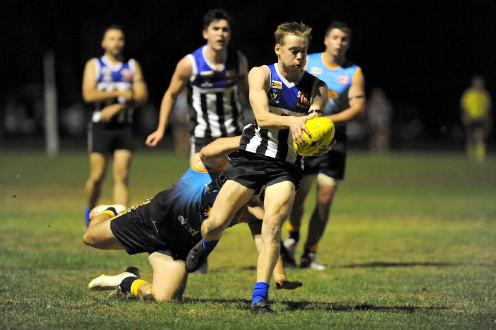 TIGHT: Oliver Young makes an effort to get the ball away under heavy pressure from a Nhill opponent in round one. Picture: SAMANTHA CAMARI