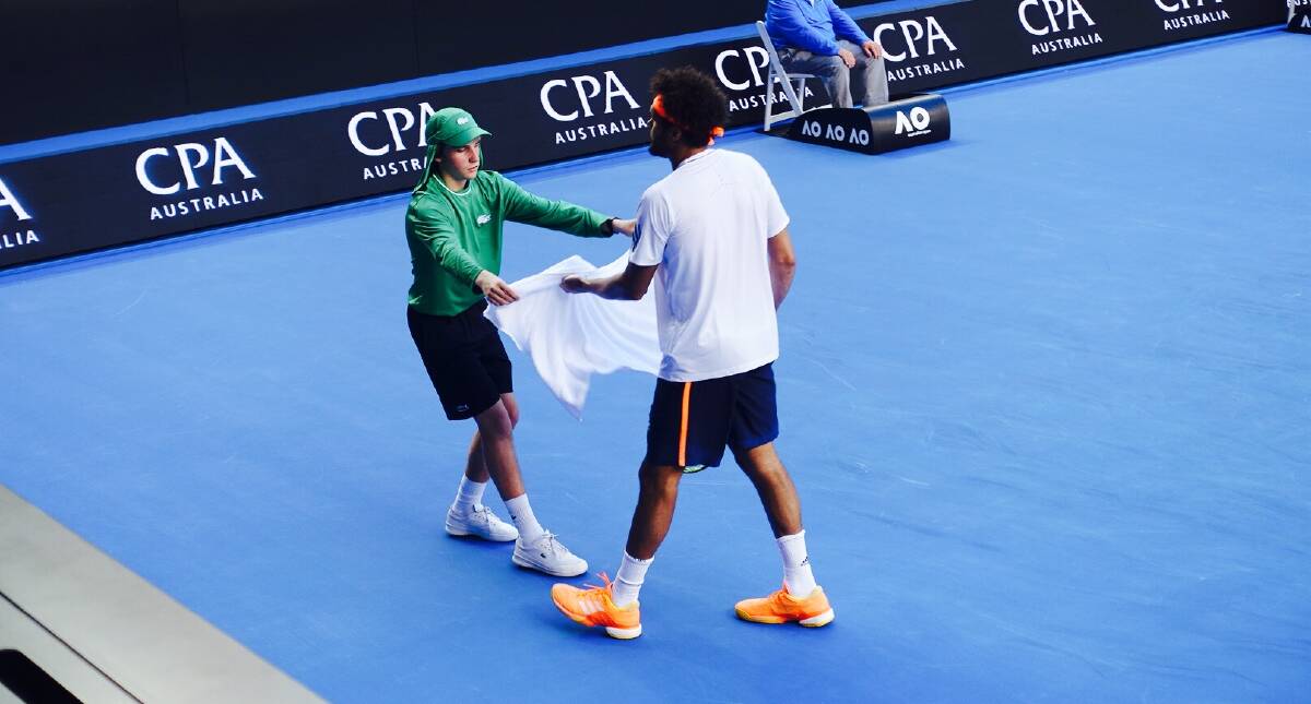 Archie Harrison hands Jo-Wilfried Tsonga his towel during his match against Dan Evans on Hisense Arena during the 2017 Australian Open.