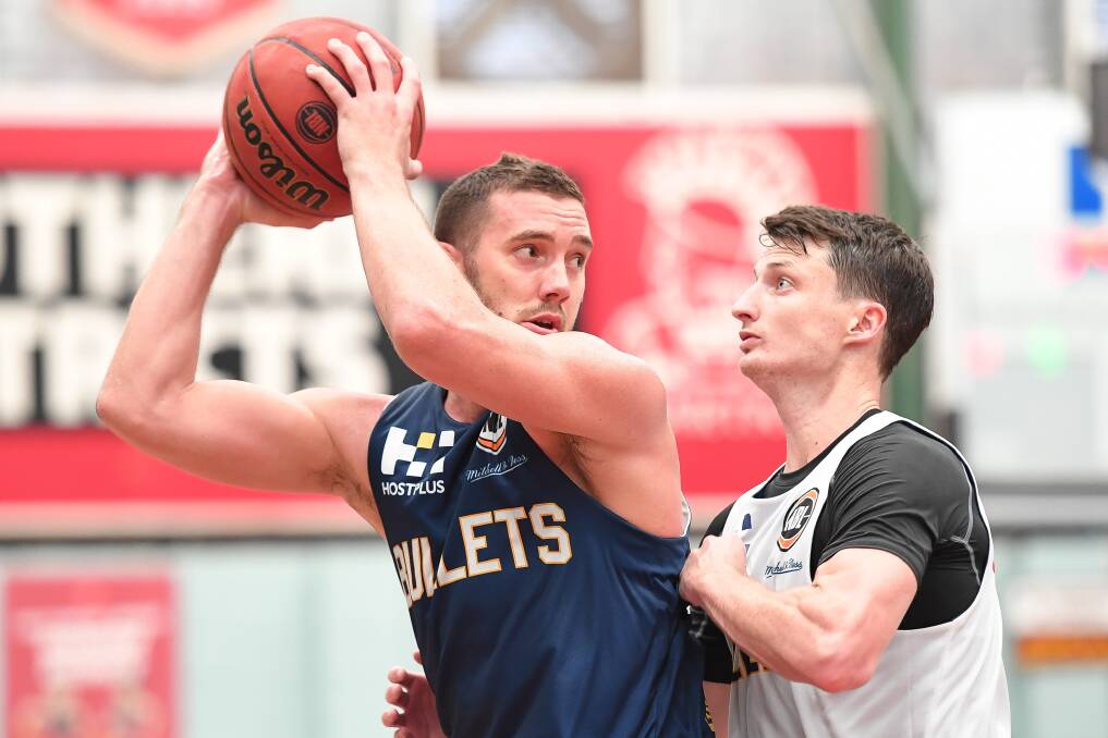 RETURN: Adam Gibson protects the ball from Shaun Bruce's defensive pressure as the Brisbane Bullets prepared to take on the Phoenix Suns. Picture: AAP Images