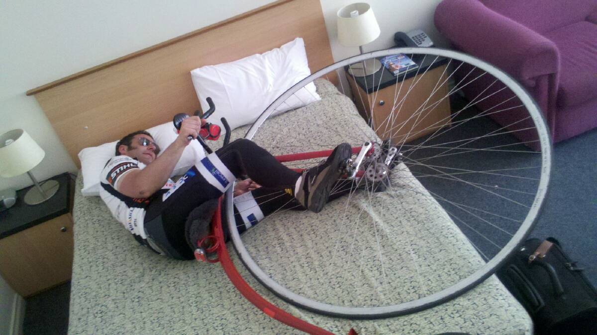 Dan Bolwell pretends to sleep with his penny farthing during the gruelling eight-day ride. Pictures: CONTRIBUTED