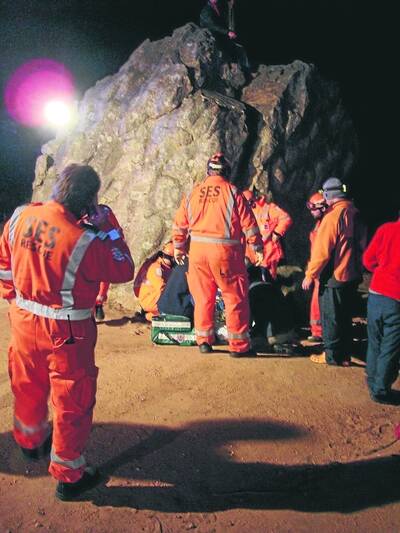 DIFFICULT RESCUE: SES and ambulance officers and climbers rescue a Melbourne teenager trapped inside a boulder at Mt Arapiles. He is in the crevice on the right, behind the ambulance officers. Picture: CONTRIBUTED