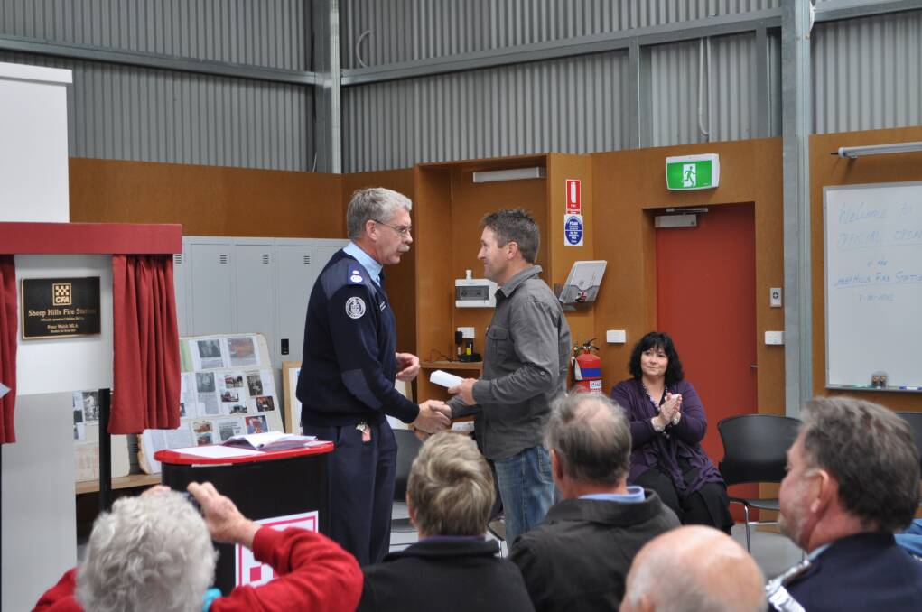 District 17 CFA acting operations manager Trevor Ebbels presents Sheep Hills captain Cameron Penny with a 10-year long service award. Picture: CONTRIBUTED