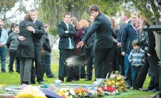 FAREWELL: Mourners comfort each other at the funeral.