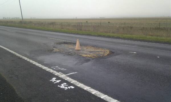 DANGEROUS: A traffi c cone sits on a large pothole on the Western Highway about three kilometres north of the Dahlen silos on Friday. Picture: JOCK BAKER
