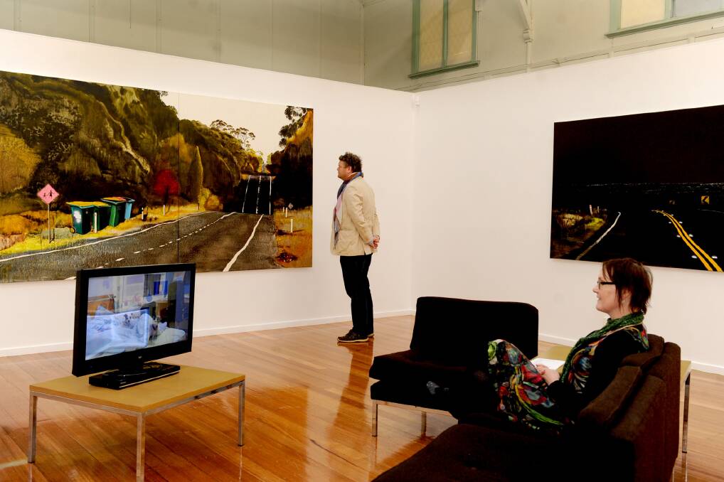Horsham Regional Art Gallery director Adam Harding and gallery curator Alison Eggleton view road trip-inspired works by Melbourne artist William Mackinnon. Picture: SAMANTHA CAMARRI