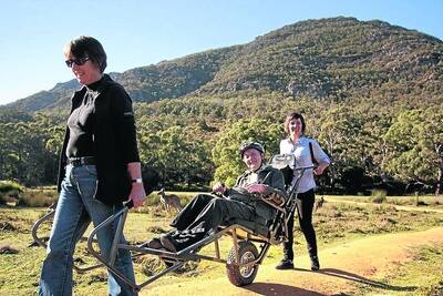 FREEDOM: Retired university lecturer and multiple sclerosis patient Dr David Stratton was moved to tears when he trialled a new specialised wheelchair in the Grampians. He is helped by wife Ros and friend Megan.  Pictures: TOM PARKES