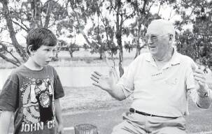 IT WAS THIS BIG: Des Hayes tells young Jack Oliver about a fish he caught. Pictures: KATE HEALY and CONTRIBUTED
