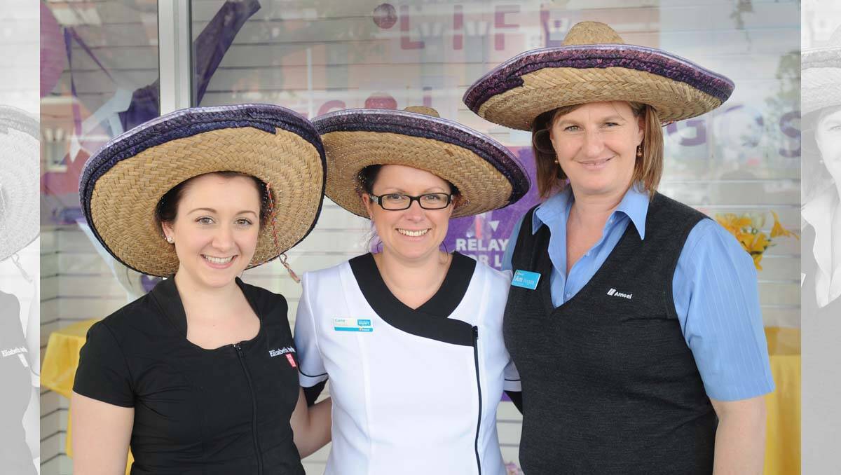The Amcal Amigos - Cadance Ingeme, Carlie Streeter and Angela Mellington - in front of their shop window.