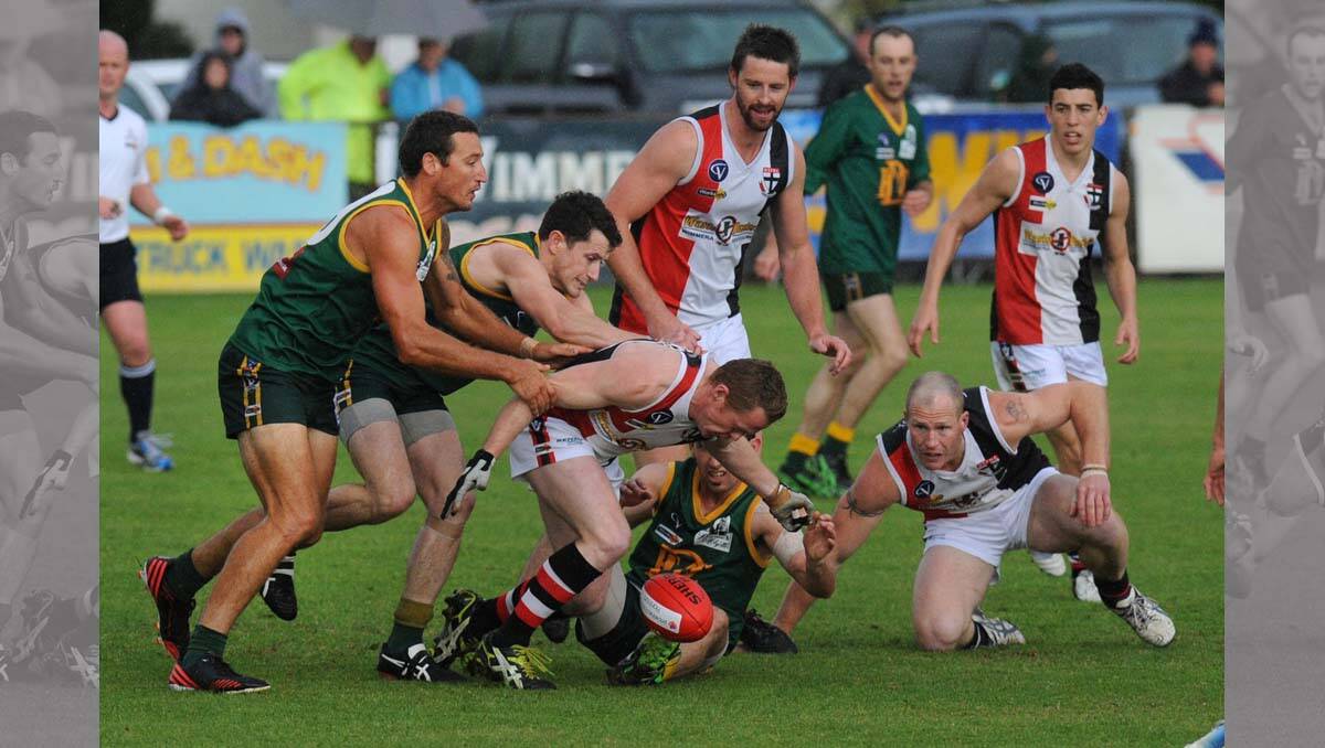 Steve Thomas tackled by Peter McFarlane and Clancy Bennett. Wimmera Football League grand final at Davis Park, Nhill. 