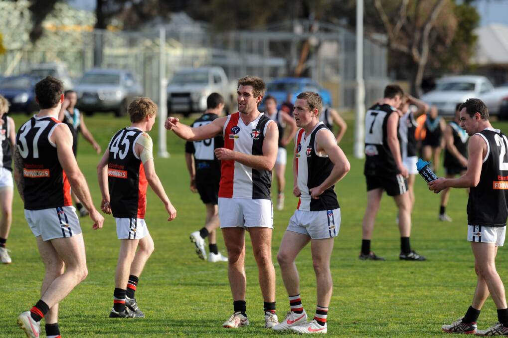 Kyran Brooks, centre, gives advice to team-mate Addison Milner during Edenhope-Apsley's loss to Swifts on Saturday. Brooks is enjoying his first season at the club.