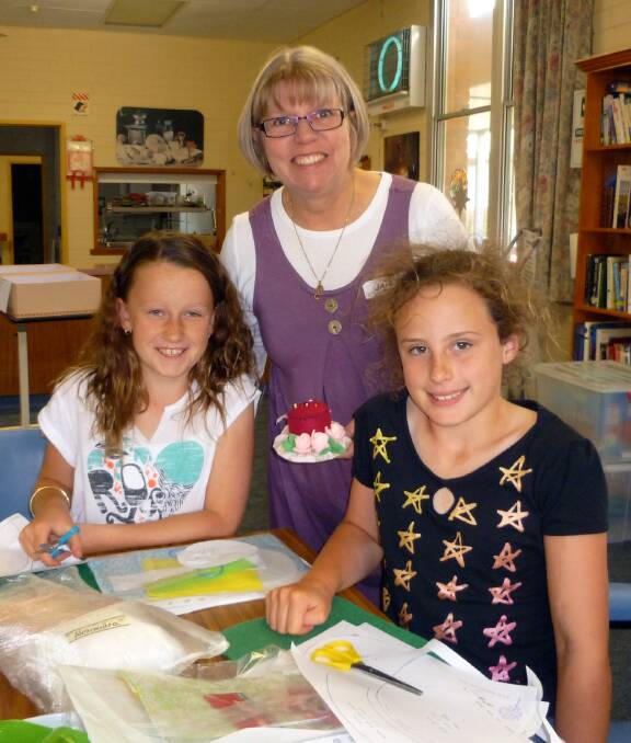 SEWING SKILLS: Volunteer Jan Ackland assists Alexandra Salter and Eloise Wills. Picture: CONTRIBUTED