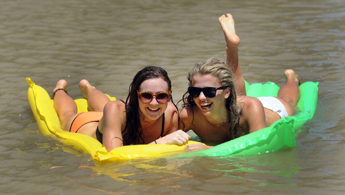 KEEPING THEIR COOL: Horsham’s Laura Haase and Violet O’Donnell-Clancy cool off in the Wimmera River at Drummond Street, Horsham, as the mercury hit 44 degrees on Tuesday. Picture: PAUL CARRACHER