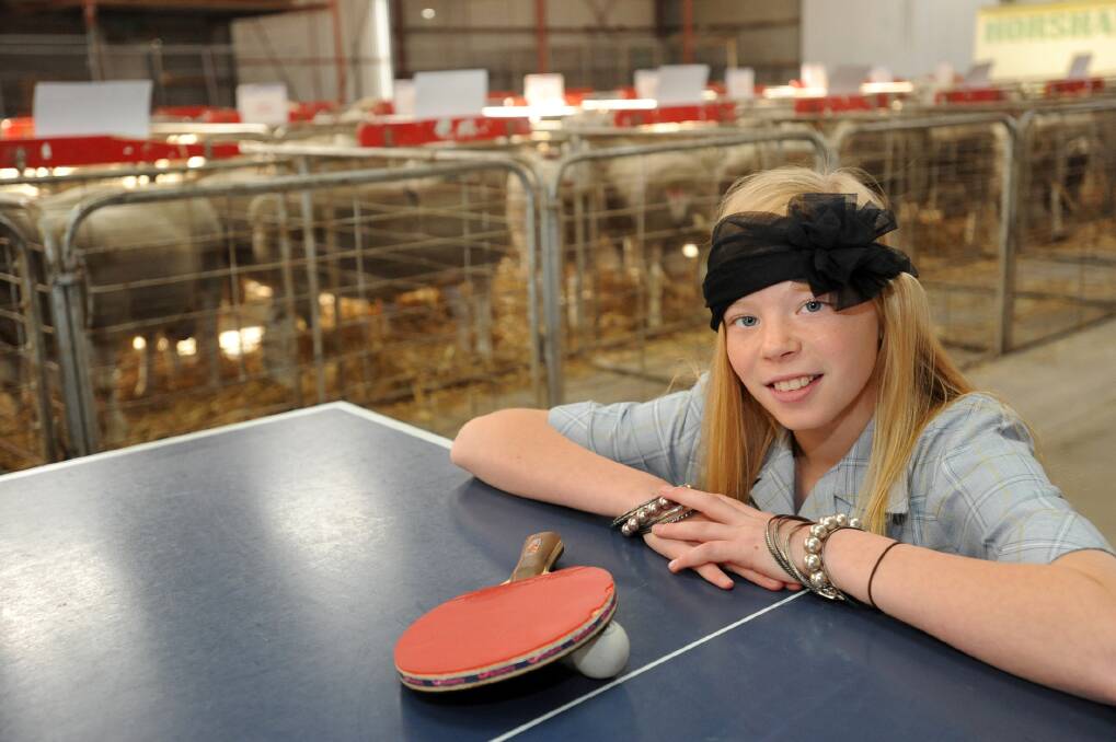 TOTALLY INADEQUATE LOCATION: Elly Blakeley plays table tennis at Maydale Pavilion with sheep in the background. Picture: PAUL CARRACHER