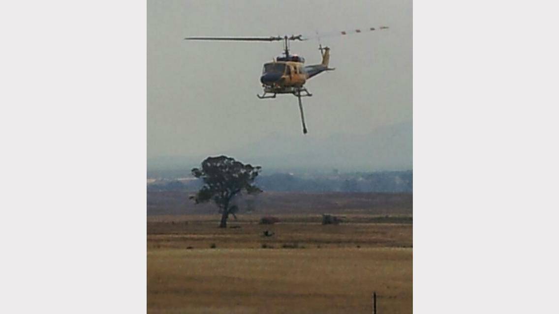 THURSDAY: Emma Kelly caught this photo of a chopper carrying dam water from farm property at Bunjils Cave Road to fight the Black Range fire about 4.30pm.