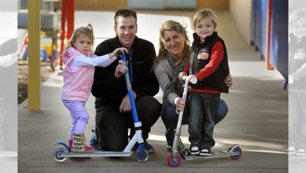 RIDING HIGH: Olivia Nunn, 2, Damien Cook, Cindy Francis and Eli Rochford, 4, at Horsham Supported Parents Playgroup. Damien Cook of Horsham Cyclery has donated two scooters for the playgroup. Picture: PAUL CARRACHER