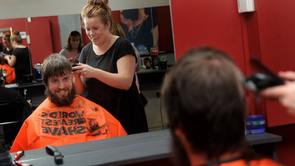 NEW DO: Tegan Kerrins shaves Karl Carman’s head for the World’s Greatest Shave. Pictures: SAMANTHA CAMARRI