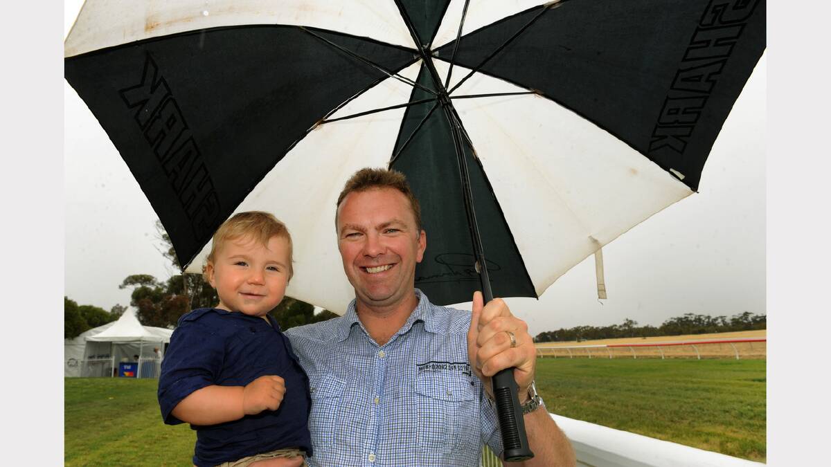 KEEPING DRY: Andrew Hitchcock and his son Lachie, 1, stay dry at Murtoa.