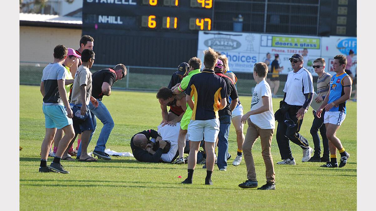 MAY: Stawell goal umpire Rob Morris and Nhill coach Darren Weavell wrestle on the ground during the incident at half time in the Stawell Warriors and Nhill clash at Central Park. The two were soon separated, but the incident sparked a melee with players from both teams involved. Picture: MARK McMILLAN